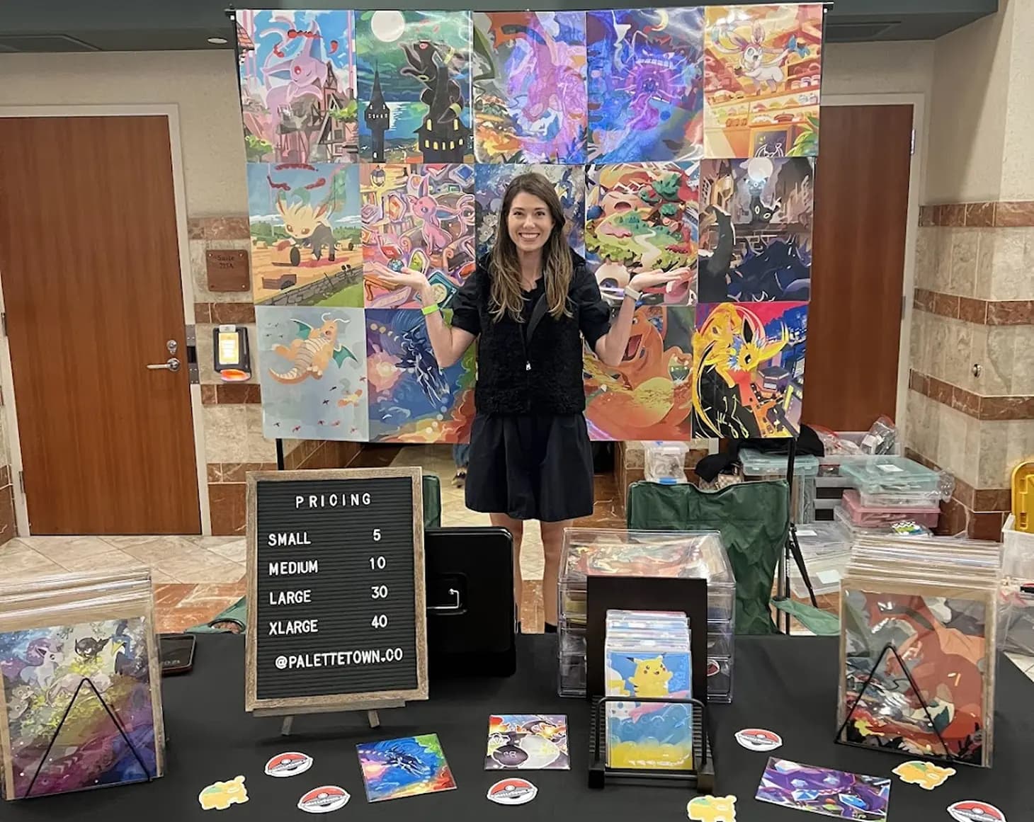 Illustrator, Kelly Warpechowski, in front of Palette Town merch booth in California